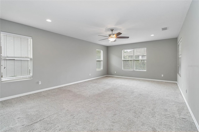 empty room with recessed lighting, light carpet, a ceiling fan, visible vents, and baseboards