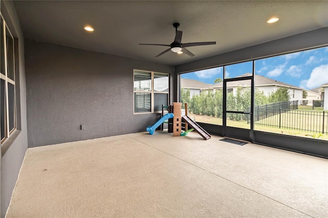 unfurnished sunroom featuring a ceiling fan