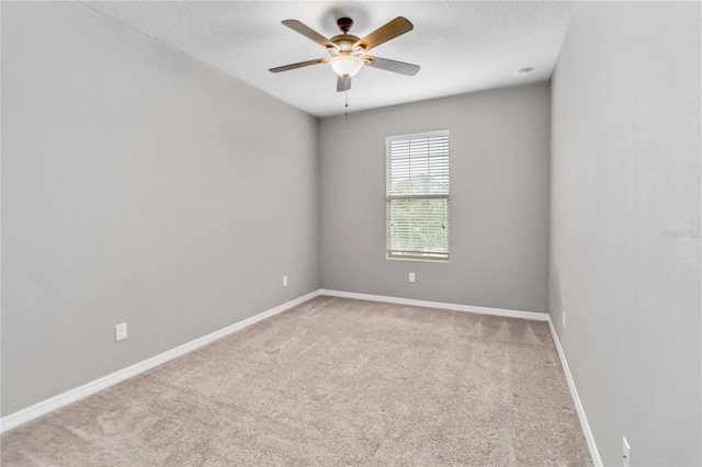 carpeted empty room with a ceiling fan, a textured ceiling, and baseboards