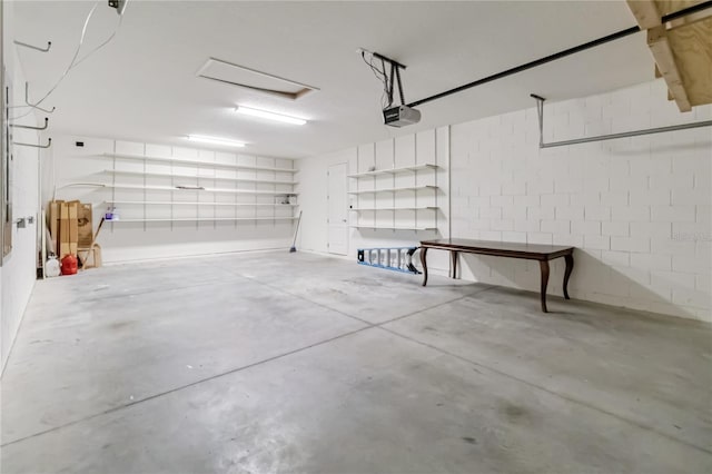 garage with concrete block wall and a garage door opener