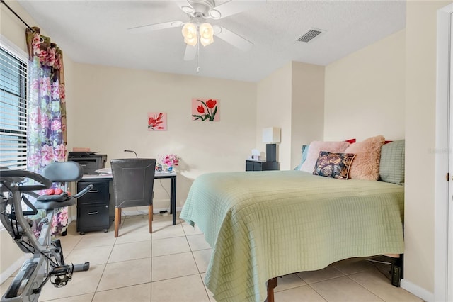 tiled bedroom featuring a textured ceiling and ceiling fan