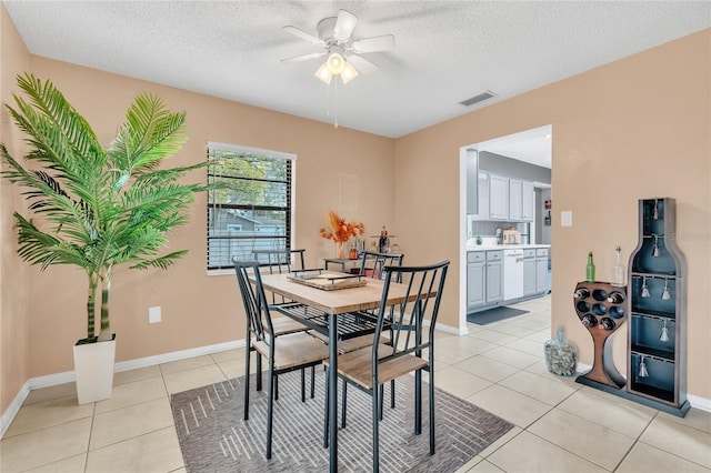 dining space featuring a textured ceiling, ceiling fan, and light tile patterned flooring