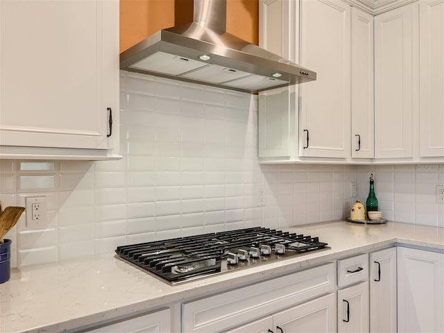 kitchen featuring stainless steel gas stovetop, island exhaust hood, and white cabinets