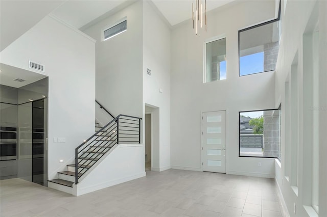 tiled foyer entrance with a towering ceiling