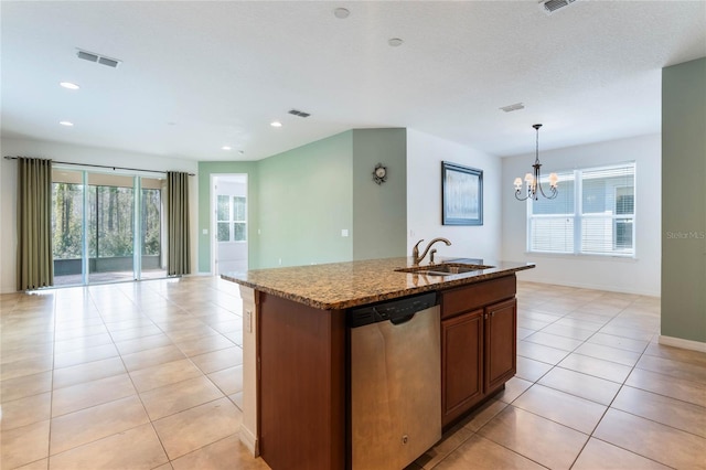 kitchen with sink, light stone counters, stainless steel dishwasher, decorative light fixtures, and a kitchen island with sink