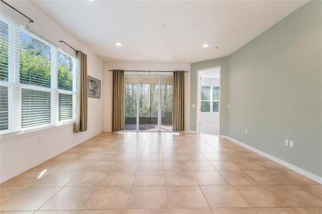 spare room featuring light tile patterned floors and a healthy amount of sunlight