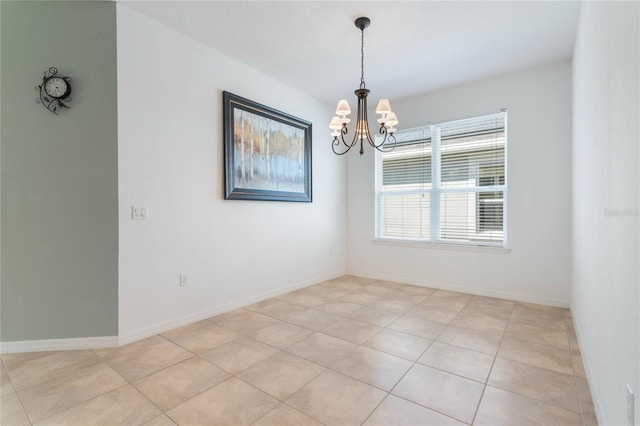 tiled spare room with a notable chandelier