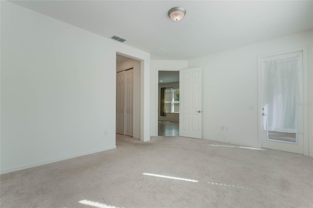 unfurnished room featuring light colored carpet