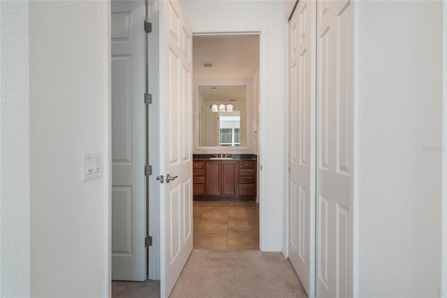 corridor with sink and light carpet