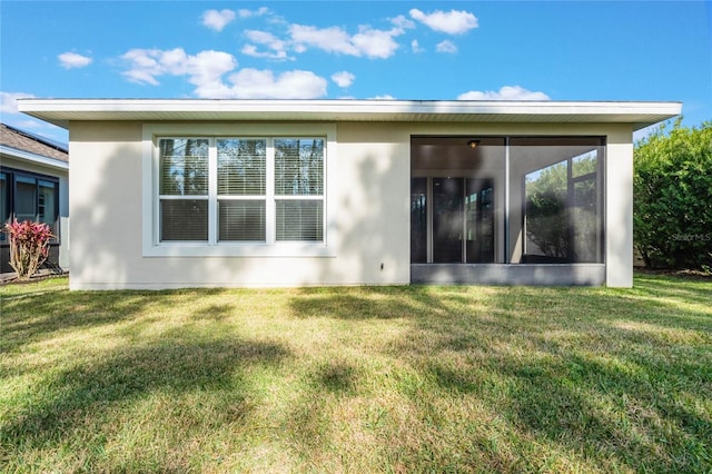 back of property featuring a sunroom and a yard