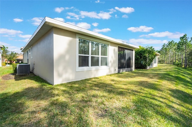 view of home's exterior featuring a lawn and central AC