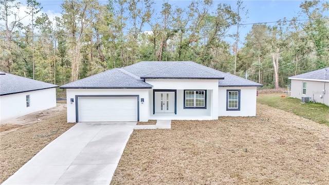 view of front of home with a garage and central air condition unit