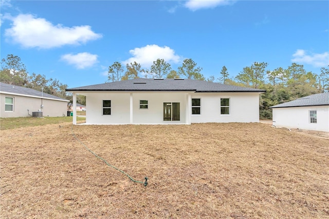 back of property with a lawn and central air condition unit