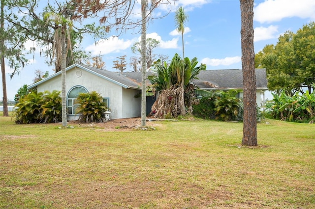 view of front facade with stucco siding and a front lawn