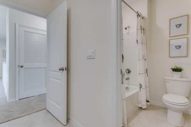 bathroom with tile patterned flooring, shower / bathtub combination with curtain, and toilet