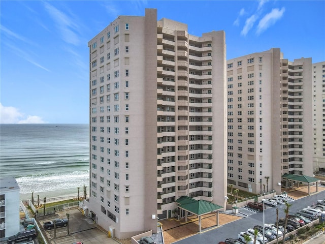 view of building exterior with a water view and a view of the beach