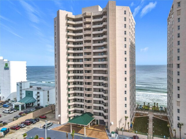 view of property featuring a water view and a beach view