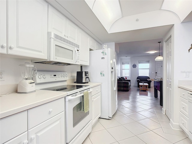 kitchen featuring light tile patterned flooring, decorative light fixtures, white cabinets, and white appliances