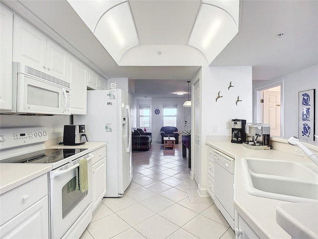 kitchen featuring white cabinets, sink, light tile patterned floors, and white appliances