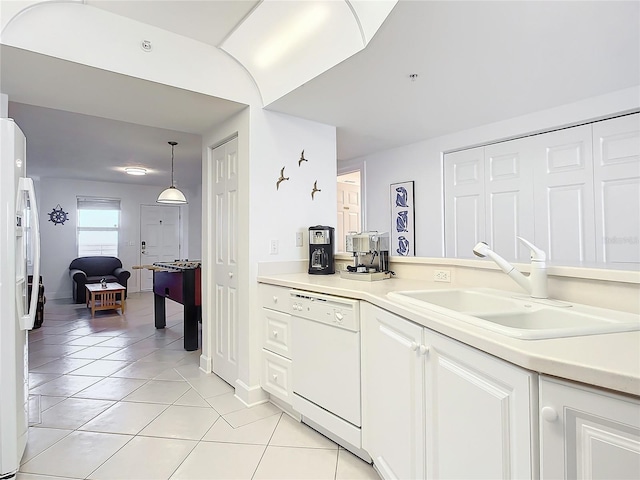 kitchen with light tile patterned floors, white appliances, pendant lighting, white cabinets, and sink