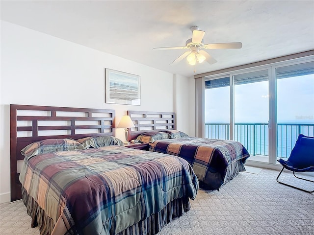 bedroom with a water view, light colored carpet, ceiling fan, and access to outside