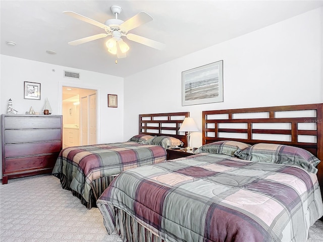 carpeted bedroom with ceiling fan and ensuite bath