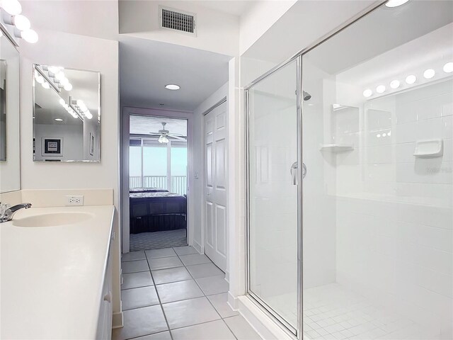 bathroom with a shower with shower door, tile patterned floors, vanity, and ceiling fan