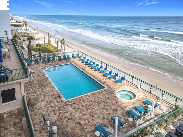 view of swimming pool with a view of the beach and a water view