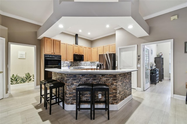 kitchen with a kitchen island, backsplash, black appliances, and crown molding