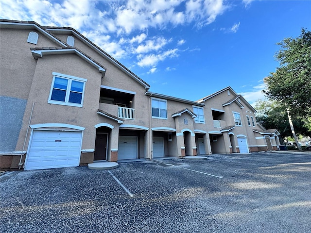 view of property with a balcony and a garage