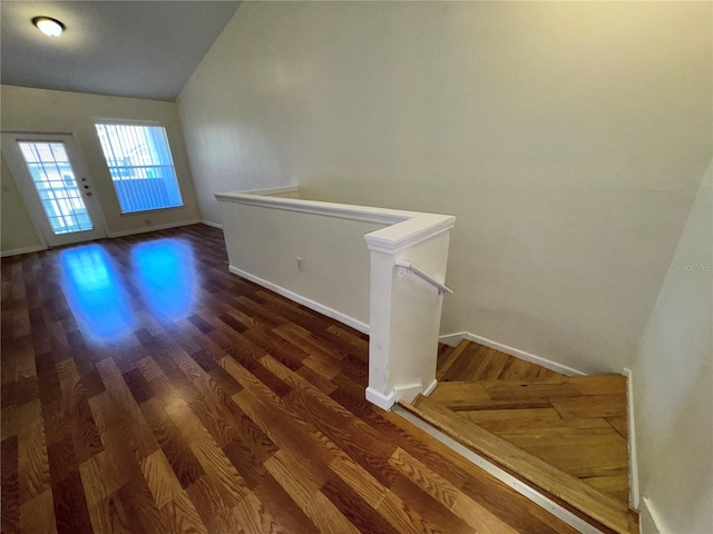 foyer entrance featuring dark hardwood / wood-style flooring and vaulted ceiling