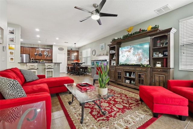 living room featuring ceiling fan, sink, and light tile patterned floors