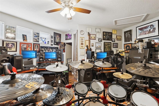 game room featuring hardwood / wood-style floors, a textured ceiling, and ceiling fan