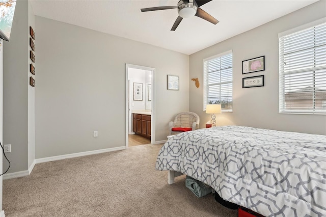 bedroom with ceiling fan, light carpet, and ensuite bath