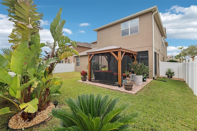 back of property with a gazebo, a yard, and a patio