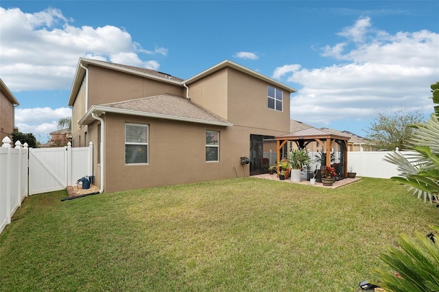 back of property featuring a gazebo, a patio area, and a lawn