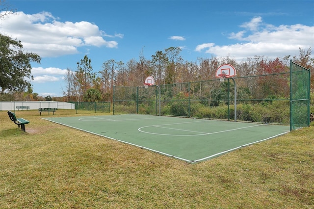 view of sport court featuring a lawn