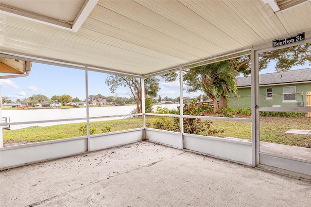 unfurnished sunroom featuring a water view