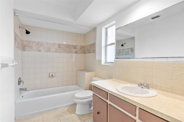 full bath featuring toilet, shower / bath combination, vanity, visible vents, and tile walls