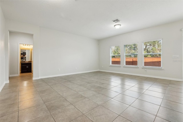 unfurnished room featuring light tile patterned floors and a textured ceiling