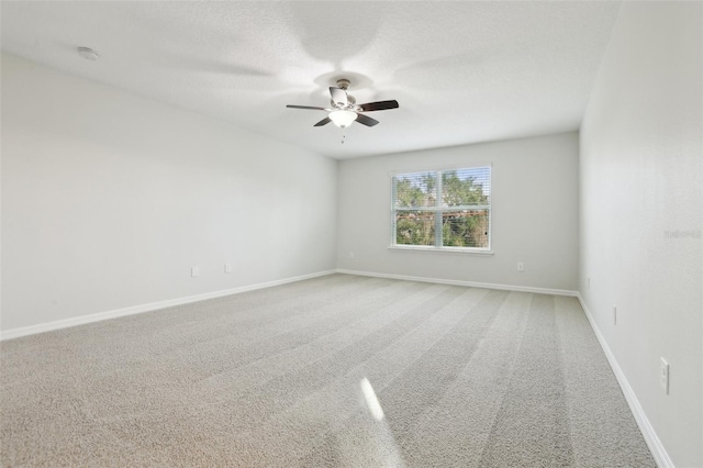 empty room featuring ceiling fan and carpet