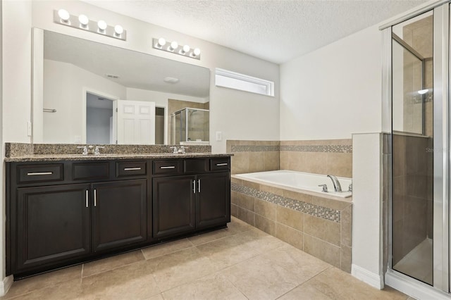 bathroom with tile patterned flooring, a textured ceiling, vanity, and separate shower and tub