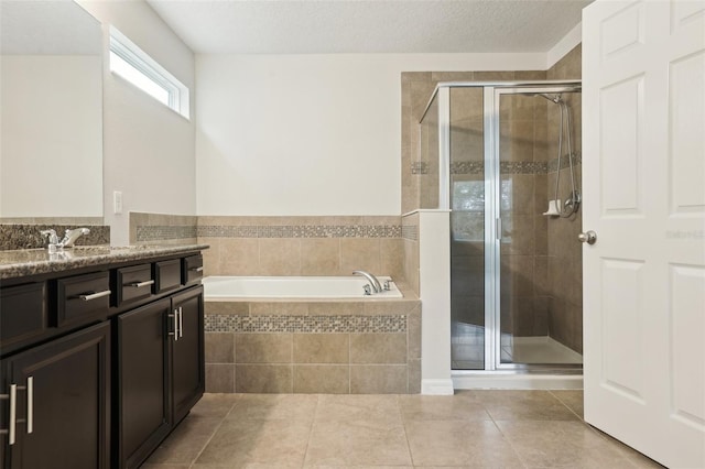 bathroom with tile patterned floors, vanity, independent shower and bath, and a textured ceiling