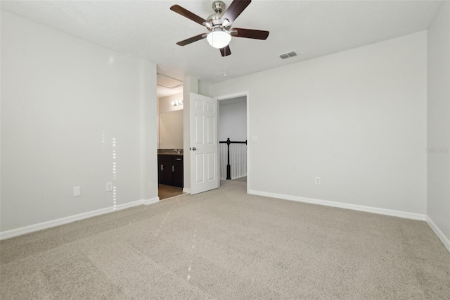 unfurnished bedroom featuring carpet flooring, connected bathroom, and ceiling fan