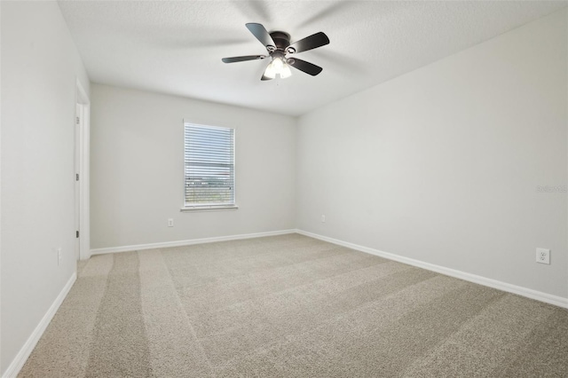 spare room with a textured ceiling, carpet floors, and ceiling fan