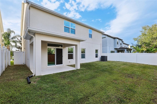 rear view of property featuring a patio, central air condition unit, and a lawn