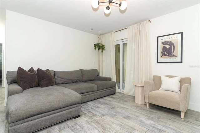 living room featuring a chandelier and light wood-type flooring