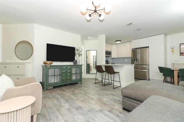 living room featuring a chandelier and light hardwood / wood-style floors