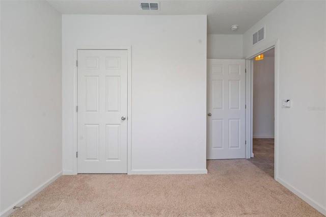 unfurnished bedroom with light colored carpet