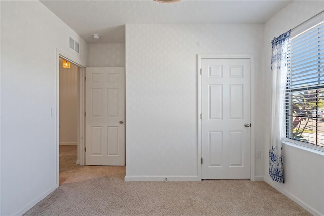 unfurnished bedroom featuring light carpet